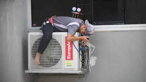 Man in Gray T-shirt Fixing the Aircon