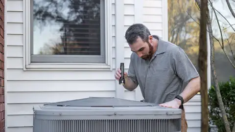 Technician Inspecting Outdoor HVAC Unit