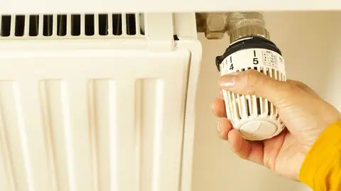 Hand of a Person Turning the Radiator Valve