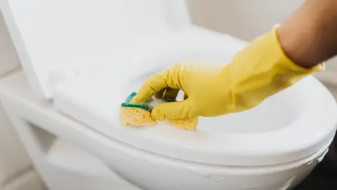 Crop Faceless Housekeeper Cleaning Toilet Bowl