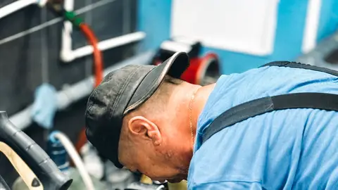 Mechanic Repairing Machine in Workshop Setting