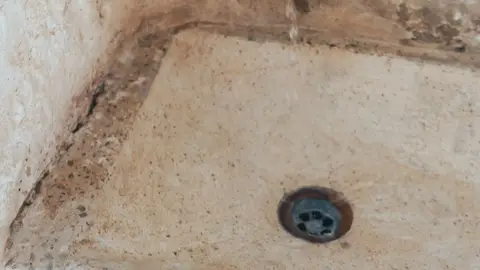 Rustic Old Faucet with Dripping Water in Sink
