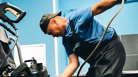 Technician Repairing Industrial Equipment in Workshop