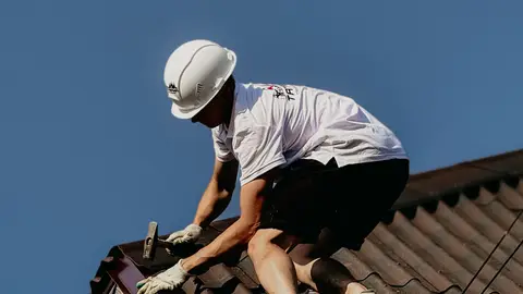 Professional Roofer Working Safely on a Building Roof
