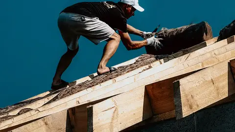 Roof Construction Worker in Action Against Clear Sky