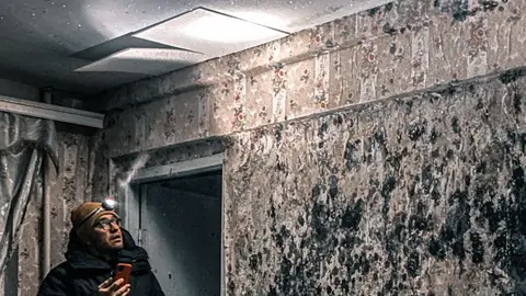 Man in Jacket Standing in Abandoned Room